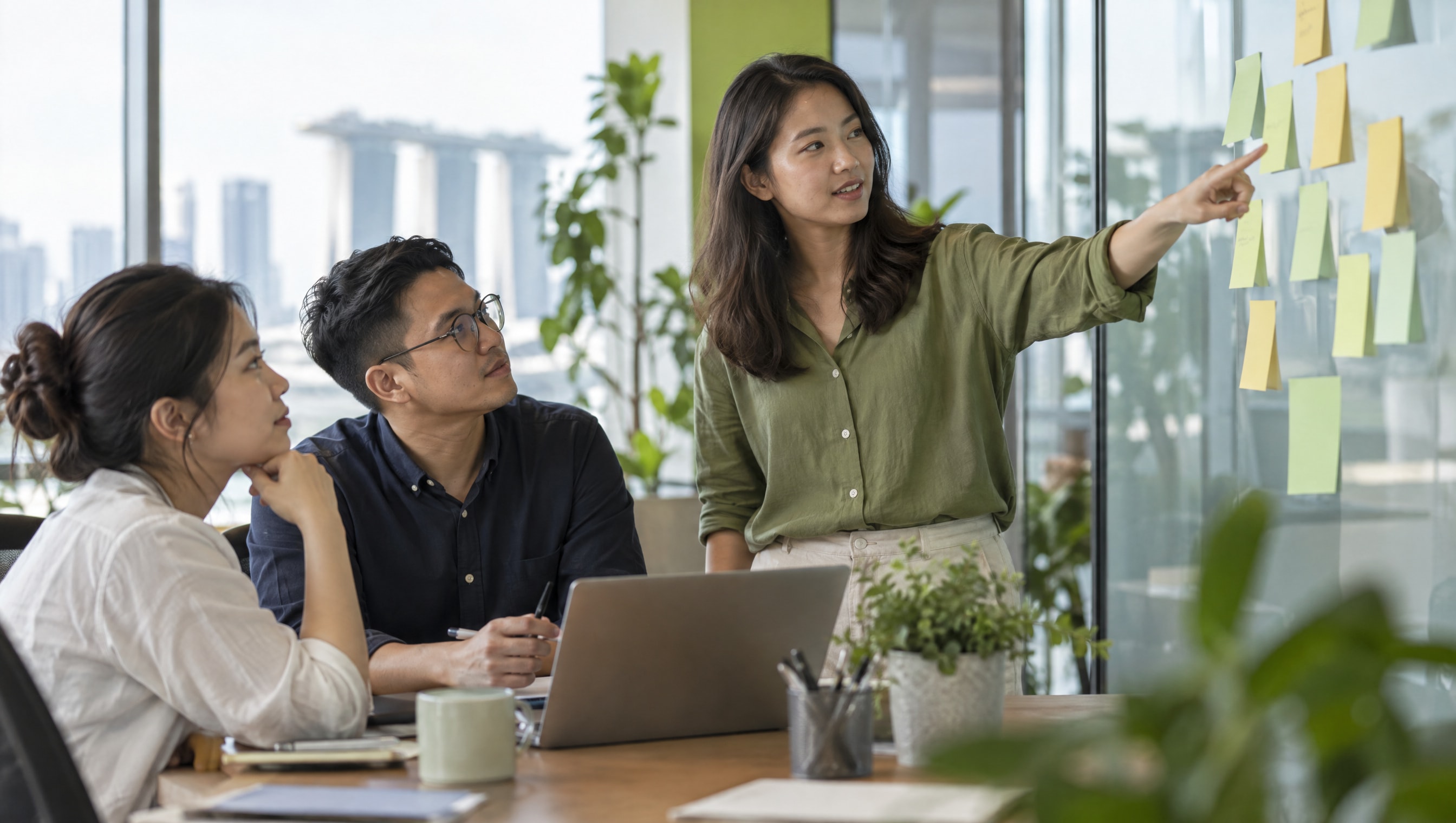 Three colleagues agreeing on a short list of questions at a meeting table